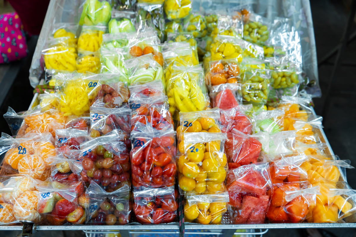 Street food market in Asia. Fruit packaged in mini plastic bags. Takeaway Fruit Snack