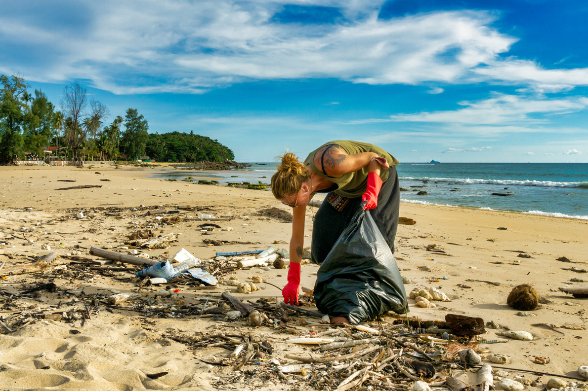 Female environmentalist tropical beach pollution cleanup